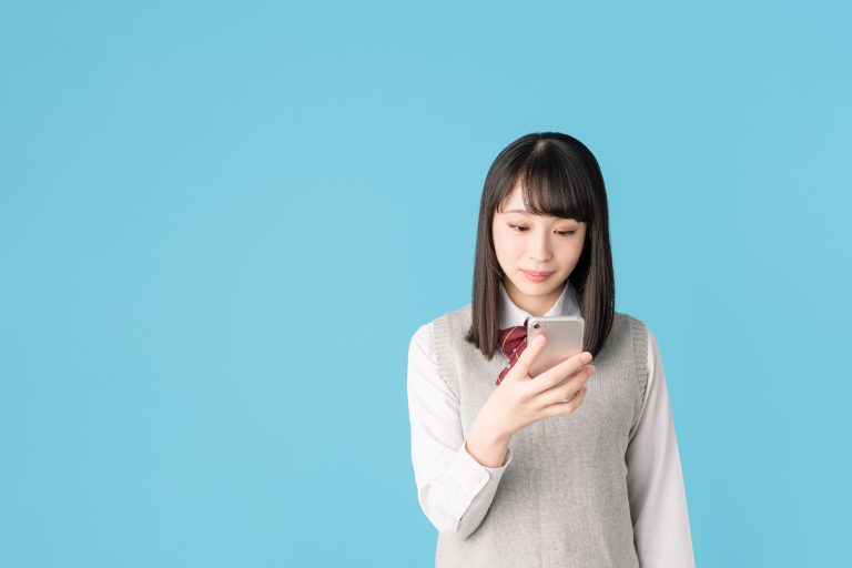 スマホを見る制服の女性