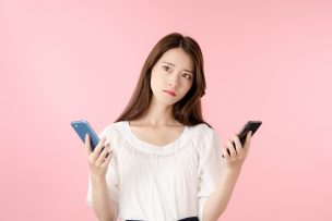 スマホを2つ持つ女性