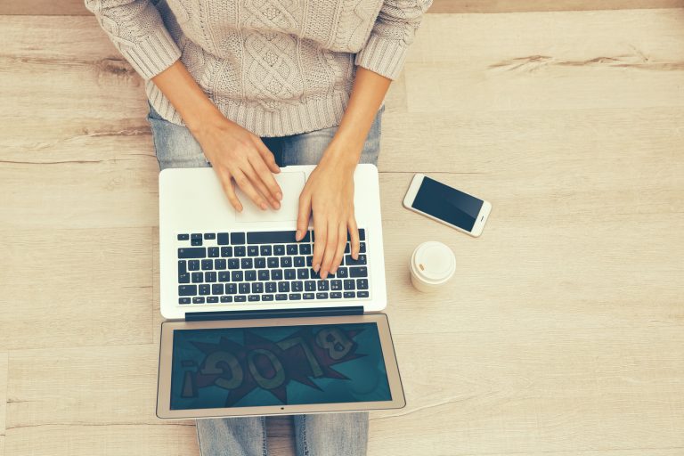 Young woman working on laptop at home, top view