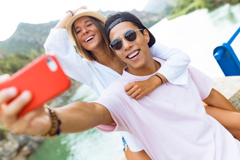 Beautiful young couple taking a selfie in the mountain.