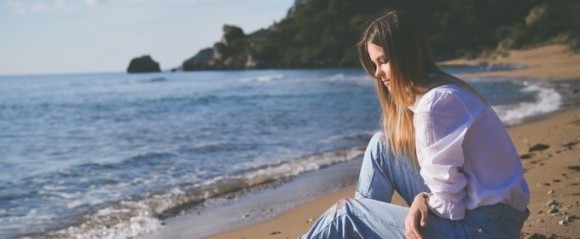 海辺で悩む女性