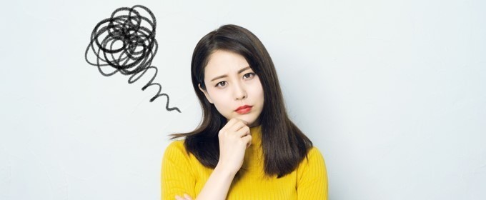 顎に手を添えて悩む女性